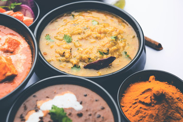 Indian Lunch / Dinner main course food in group includes Paneer Butter Masala, Dal Makhani, Palak Paneer, Roti, Rice etc, Selective focus