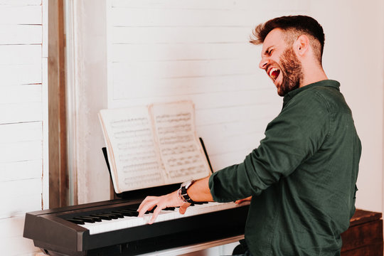 Young Man Playing Electric Piano At Home