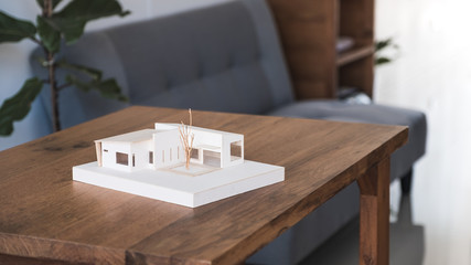 An architecture model on wooden table in office with blur nature background