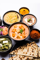Indian Lunch / Dinner main course food in group includes Paneer Butter Masala, Dal Makhani, Palak Paneer, Roti, Rice etc, Selective focus