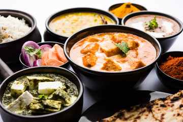 Indian Lunch / Dinner main course food in group includes Paneer Butter Masala, Dal Makhani, Palak Paneer, Roti, Rice etc, Selective focus