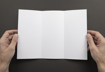 Obraz premium Mens hands holding white booklet