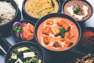 Indian Lunch / Dinner main course food in group includes Paneer Butter Masala, Dal Makhani, Palak Paneer, Roti, Rice etc, Selective focus