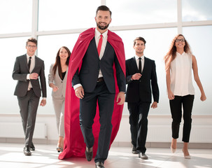 businessman is a superhero, stepping ahead of his business team