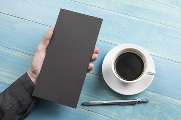 Mens hand holding black flyer