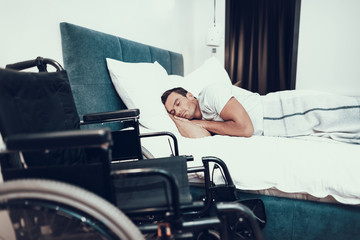 Disabled Man Sleeps With Wheelchair in Foreground