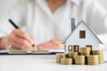 Business woman signing contract to buy house, insurance or loan real estate on table.