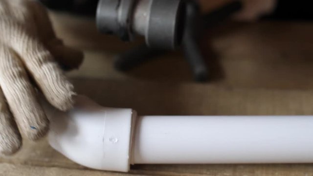 Hands in gloves connect plastic pipes together. 4k 60fps slow motion. Brazing of pipes made of polycarbonate. Connection of water pipe parts.