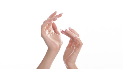 Closeup of beautiful female hands applying hand cream isolated on white background.