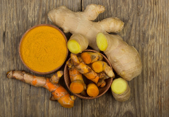 slices of turmeric and ginger on wooden background
