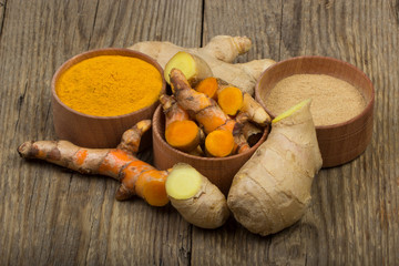 slices of turmeric and ginger on wooden background