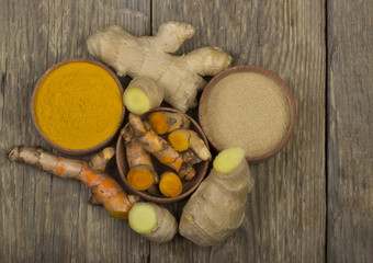 slices of turmeric and ginger on wooden background