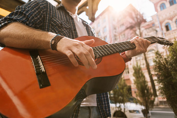 Music everywhere. Close up of male hands holding chord and touching strings