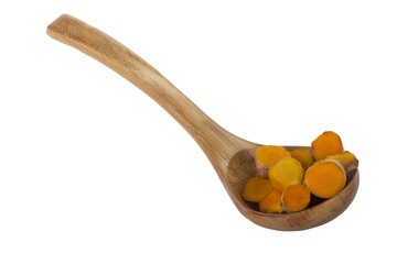 heap of slices of turmeric in wooden spoon isolated on white background