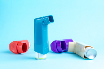Various asthma inhalers on a blue background