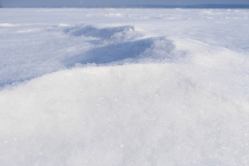 Fototapeta na wymiar Close-up snowdrift white loose fresh snow. Perspective view. 