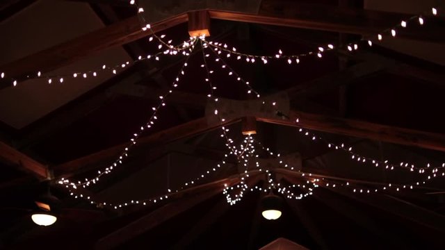 String lights hanging on farm ceiling night slight parellax.mov