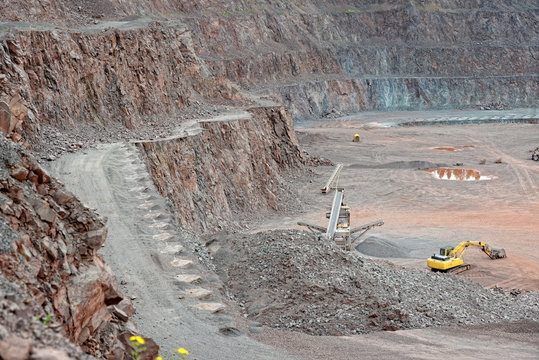 Stone crusher and excavator in a porphyry quarry. mining industry.