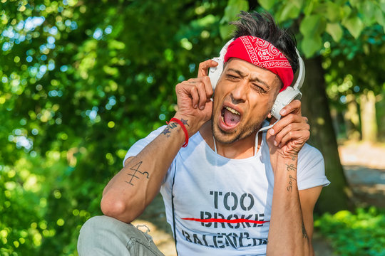 Extravagant (hipster) male model is singing in nature.