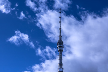 Obraz premium The top part of Ostankino tower TV and radio broadcasting. Against white clouds and blue sky
