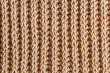 The texture of a brown knitted yarn. Knitted and winter clothes