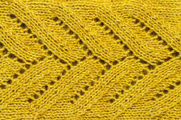 The texture of a color of mustard knitted yarn. Knitted and winter clothes