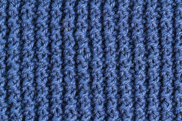 Fototapeta premium The texture of a blue knitted yarn. Knitted and winter clothes