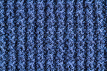 The texture of a blue knitted yarn. Knitted and winter clothes
