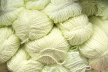 Yarn for hand knitting lemon-colored skeins. Background texture.