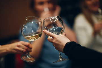 People clink glasses with wine. Cheers concept.