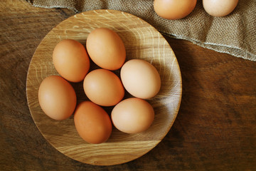 Easter background. Rustic wooden table with plate, egg, jute bag . Top view