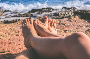 Female and male naked legs on rocks close-up