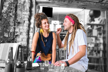 Falling in love. Bearded man with dreadlocks falling in love with his beautiful girlfriend wearing bright accessories