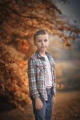 Fototapeta premium boy stands on a meadow before sunset
