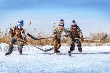 Boys play hockey on a frozen lake