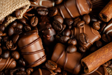 Assortment of white, dark, and milk chocolate. Chocolate with cream, nuts, almonds, hazelnuts and cinnamon with coffee beans. Sweet food and no diet concept.