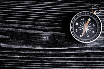 compass on dark wooden background concept direction motion top v
