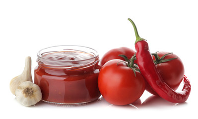 Red sauce in a jar and fresh ingredients, tomatoes, peppers and garlic on a white isolated background. Tomato sauce. Ketchup