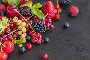 Mixed berries on a dark background with selected focus. Strawberries, Raspberries Blackberries, cherries, red and yellow currents. Healthy Living and Nutritious Food concept.