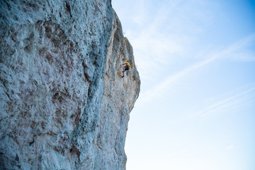 View of man without helmet hanging on a rope while rappelling and shows flying pirouettes in the air  © pablobenii