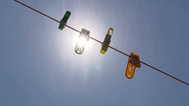 Sunlight shining through colorful clips on string