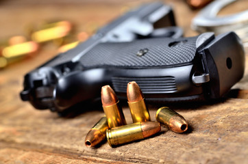 Obraz premium Close-up of 9mm handgun, bullets and handcuffs