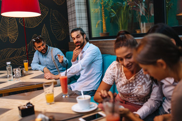 Boys flirt with girls in a cafe