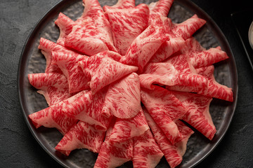A close up detailed image of sliced Japanese wagyu beef in a ceramic plate prepared for Shabu Shab