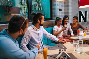 Boys flirt with girls in a cafe