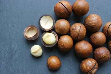 Obraz premium Macadamia nuts on a wooden table close-up. Healthy food, healthy lifestyle, diet, vegetarianism.