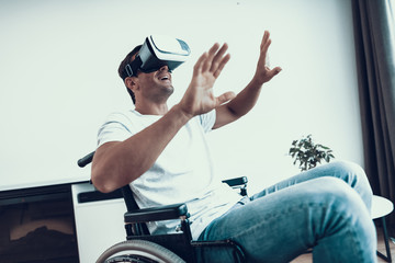 Disabled Man with Hands Up Wearing VR Goggles