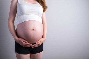 pregnant women with hands on cute pregnant belly