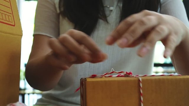 Business owner work at home wrapping parcel box, Alpha generation life style. Business woman entrepreneurial successful. Sales Online Parcel delivery. New generation life style of young entrepreneur.