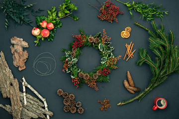 wreath garland on dark blackboard background with natual christmas elements,branches,pomegranate,cinnamon,coffee cup.Xmas winter holiday season social media card